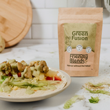 Green Fusion Friendly Blends spice blend package with chicken and pineapple wrap on a marble countertop