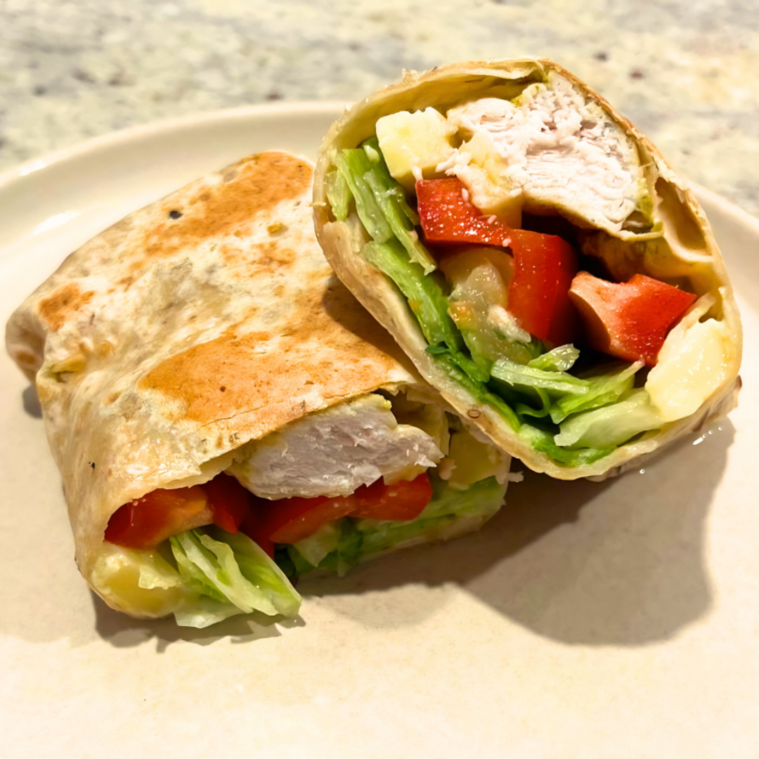 Chicken and Pineapple wrap cut in half on n a white plate
