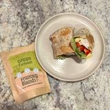 Chicken and Pineapple Wrap on a white plate with low FODMAP Friendly Blends Green Fusion spice blend package on a speckled countertop
